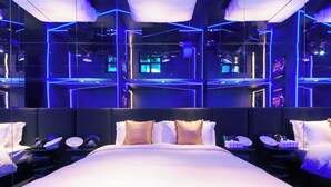 A modern hotel room with a large bed, bedside tables, and a mirror. - Space Design Hotel (Dalian)