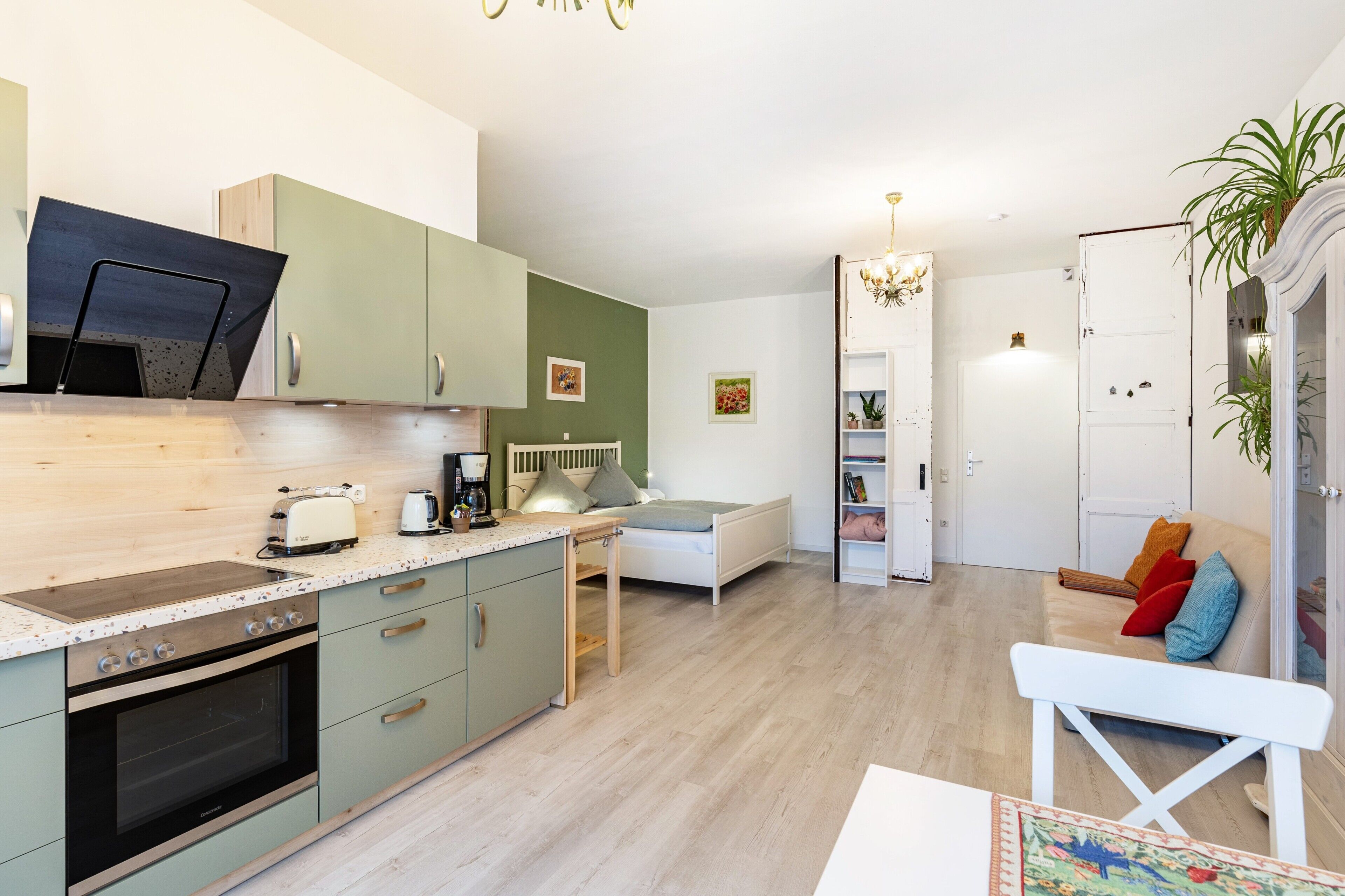 Een moderne keuken met een inbouwoven, een eettafel en een bank.