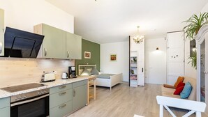 Cozinha moderna com forno embutido, mesa de jantar e um banco.