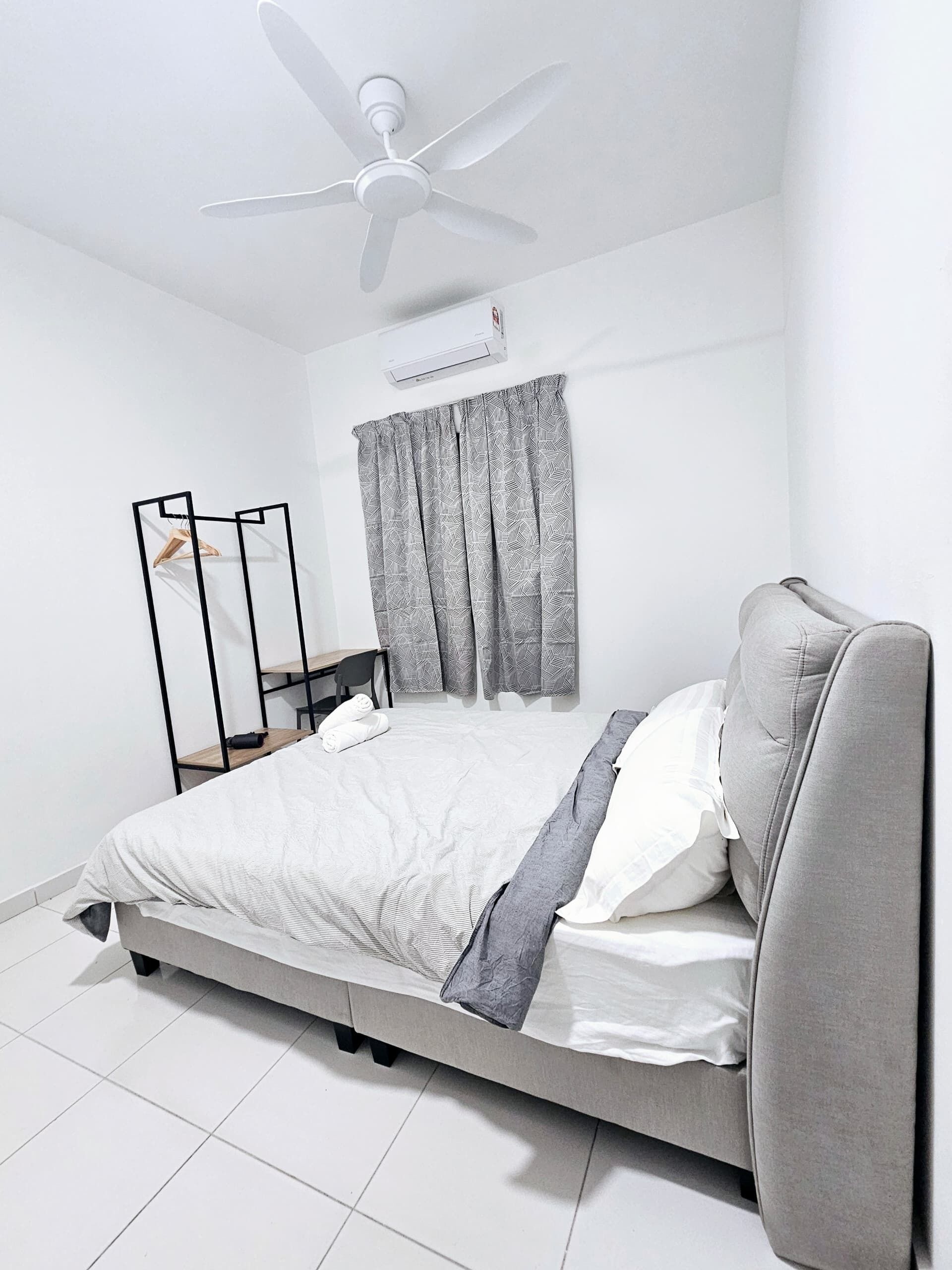 A modern bedroom with a bed, a ceiling fan, and a window with curtains.