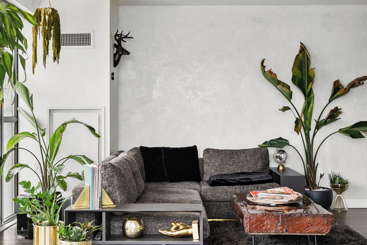 A modern living room with a grey sofa, a coffee table, and various decorative items.
