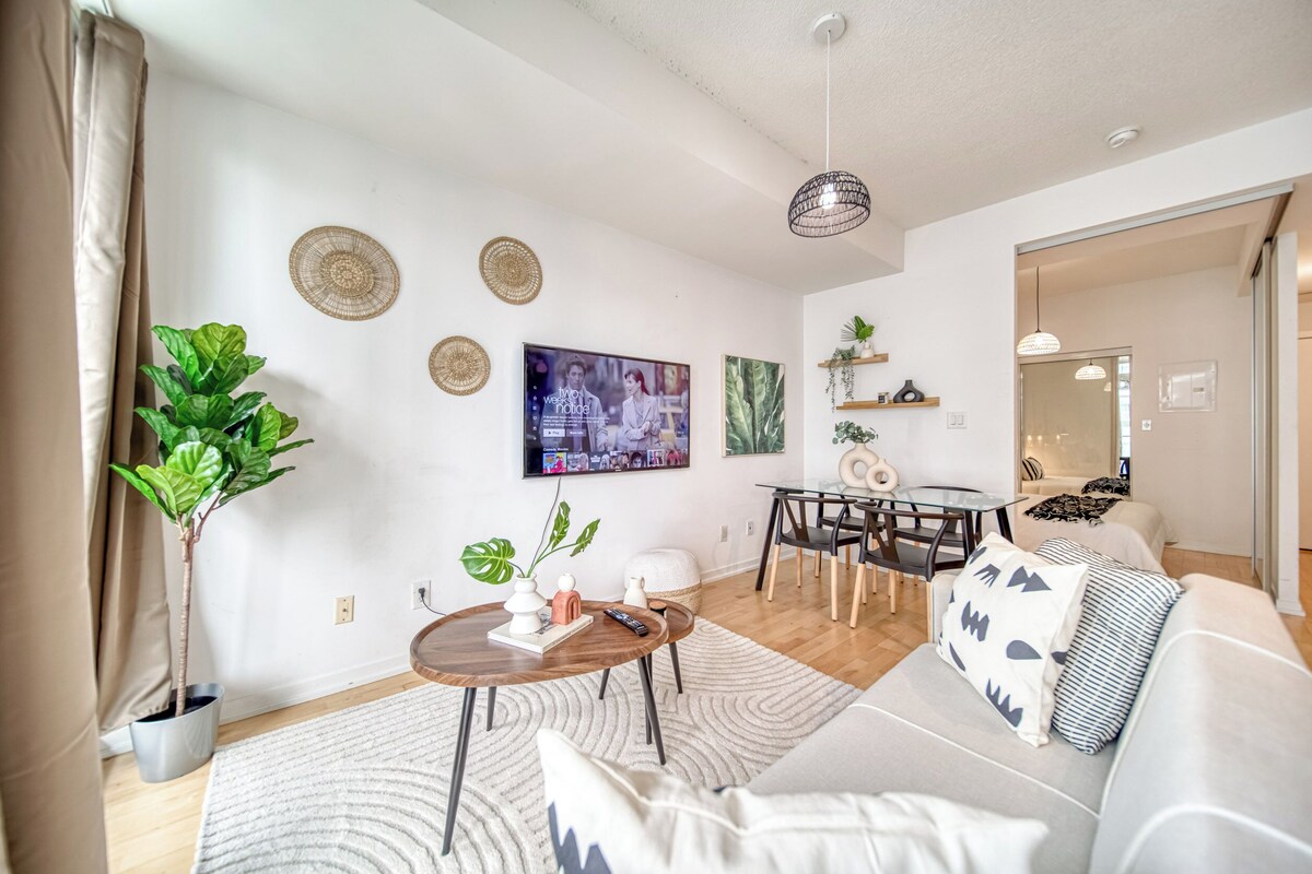 A modern living room with a sofa, coffee table, and a TV mounted on the wall.
