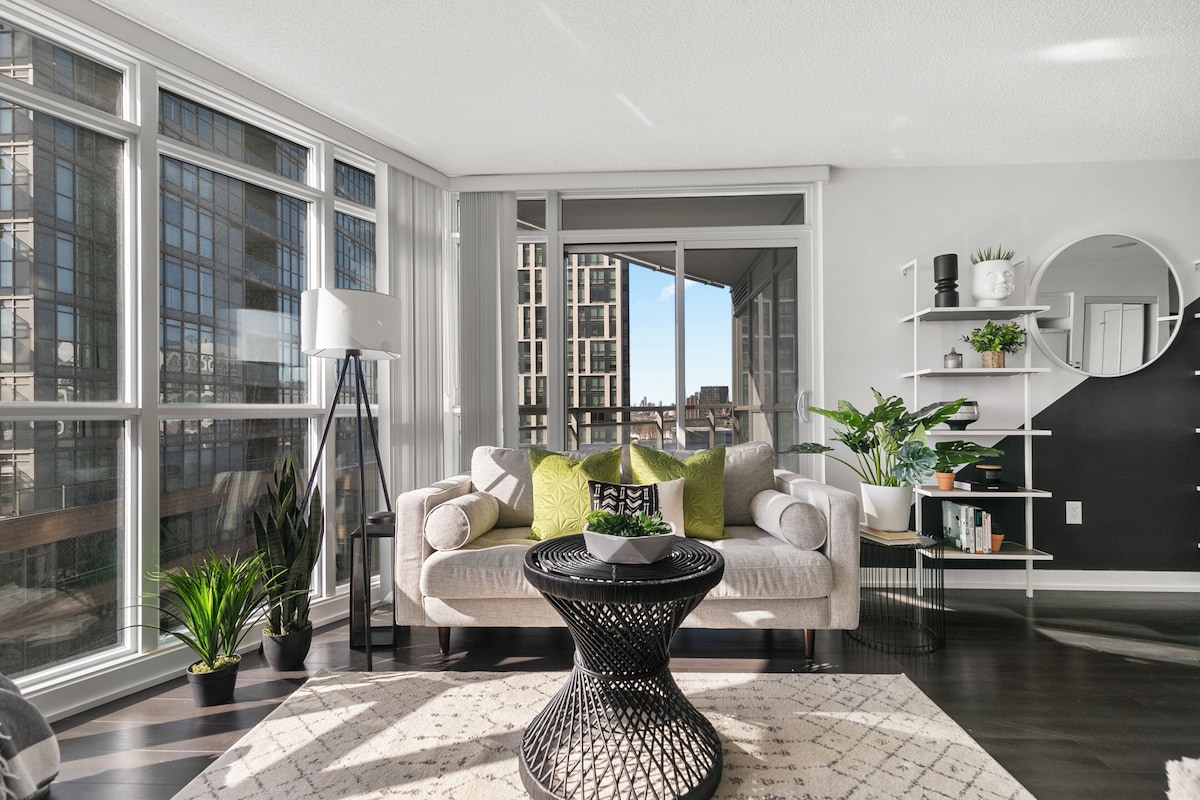 A modern living room with a sofa, a coffee table, and potted plants.