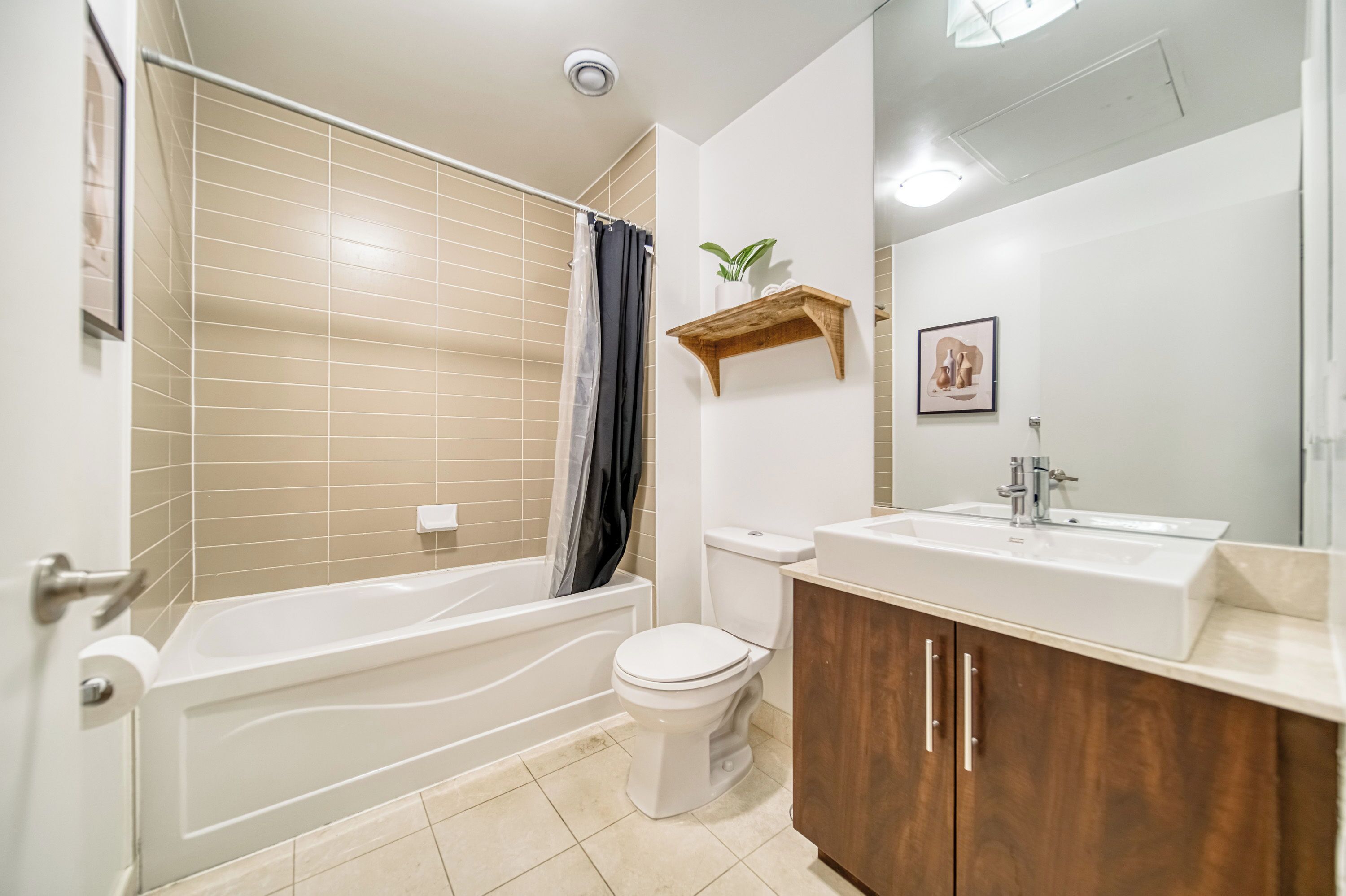 A modern bathroom with a bathtub, toilet, and vanity.