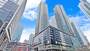 A modern urban skyline with high-rise buildings, including a prominent glass-fronted structure. - Gsuite Express Downtown Toronto (Toronto)