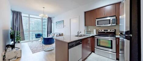 Una cocina moderna con electrodomésticos de acero inoxidable, lavavajillas integrado y una isla grande con un lavamanos.