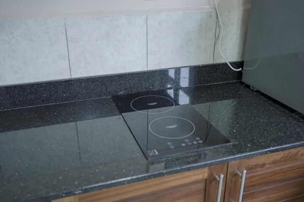 A kitchen with a black countertop and a built-in induction cooktop.