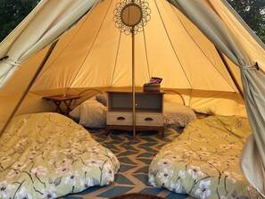 A tent with a bed, a small table, and a mirror. - Elm - Bell Tent 2-4 Person Anglesey, North Wales (Holyhead)