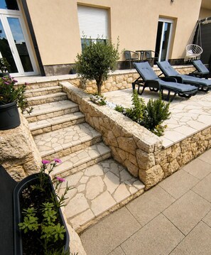 A stone staircase leading to a patio with lounge chairs and potted plants. - Aparment With Private Pool ,shades of Bluemm (Imotski)
