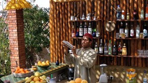 Un espace bar avec une variété de bouteilles et une personne qui prépare une boisson.