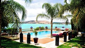 Un espace aménagé au bord de la piscine, avec des chaises longues, une petite piscine et une vue sur la mer.