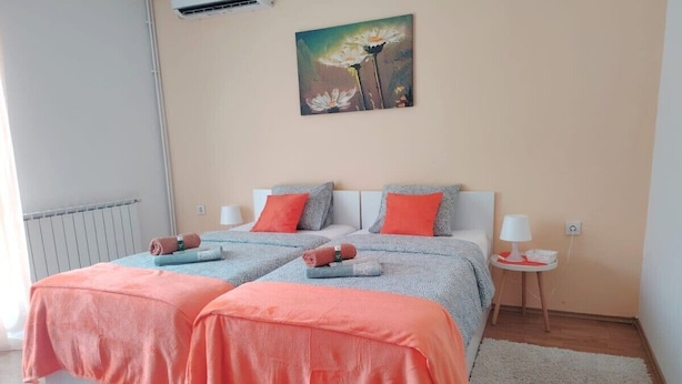 Un lit double avec deux oreillers, une table de chevet avec une lampe et un tableau au mur.