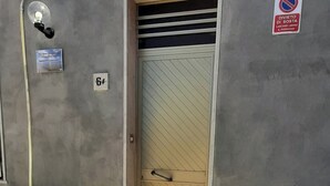 A building entrance with a door, a no parking sign, a light fixture, and a barrel. - The house of the islands Sea View ( The House Of The Islands ) (Marausa Lido)