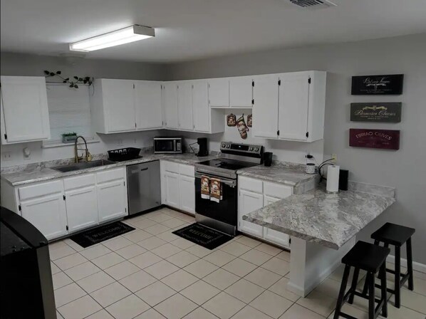 Enjoy cooking in this well-equipped kitchen with oven, microwave, and granite countertop.