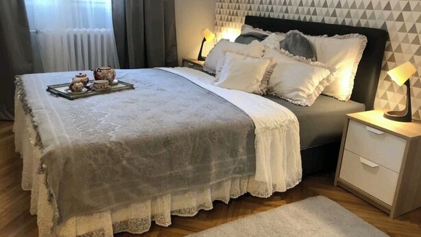 Une chambre à coucher bien rangée, avec un lit, des tables de chevet et une lampe de chevet.