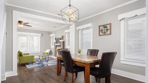 A dining area with a wooden table and chairs, a ceiling fan, and a hanging light fixture. - Charming 4-bedroom 3bath house in terrific Florence with WiFi, AC (Florence)