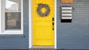 A bright yellow door with a wreath, a mailbox with the number 905, and a window with blinds. - Charming 4-bedroom 3bath house in terrific Florence with WiFi, AC (Florence)