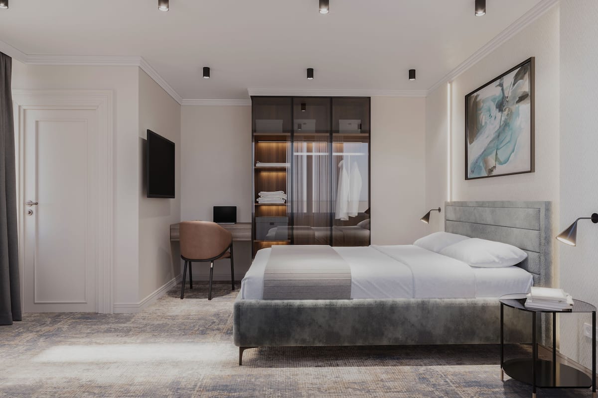 Ein modernes Schlafzimmer mit Bett, Schreibtisch, Stuhl und Kleiderschrank.