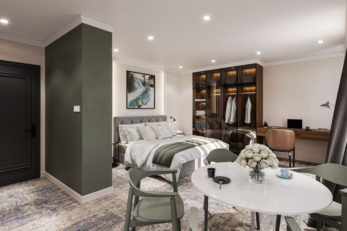 Ein modernes Schlafzimmer mit Bett, Schreibtisch, Stuhl und rundem Tisch.