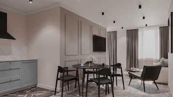 A modern kitchen with dark cabinetry, a marble countertop, and recessed ceiling lights.