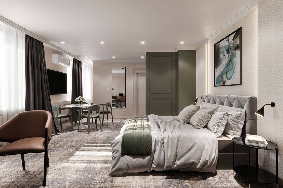 Ein modernes Hotelzimmer mit einem großen Bett, einem Schreibtisch und einem Stuhl. An der Wand hängt ein Gemälde und ein Fenster mit Vorhängen.