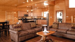 L’intérieur d’une cabane en rondins comprend un salon, une cuisine et un coin repas.