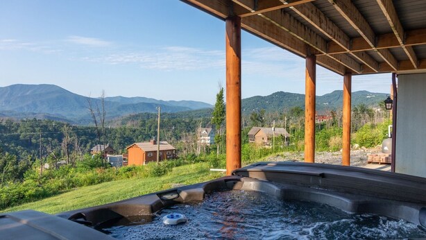 Un bain à remous avec vue sur les montagnes et les maisons.