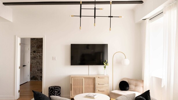 Una sala de estar moderna con un sofá, una mesa de centro, un televisor y un mueble.