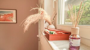 Una encimera de cocina con un difusor, una caja de madera y un florero con plantas secas.