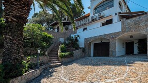 A stone-paved courtyard with a staircase leading to a building with multiple doors and windows. - Large house, pool, AC, parking - 13 guests (Vall-llòbrega)