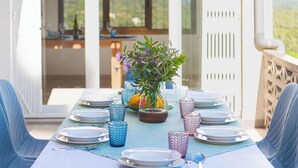 A dining table set with plates, cutlery, and glassware, with a potted plant in the center. - Large house, pool, AC, parking - 13 guests (Vall-llòbrega)