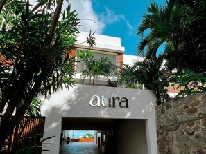 A building entrance with the name 'aura' prominently displayed. - Charm & Serenity with Private Terrace and Garden View (Saint-Martin)