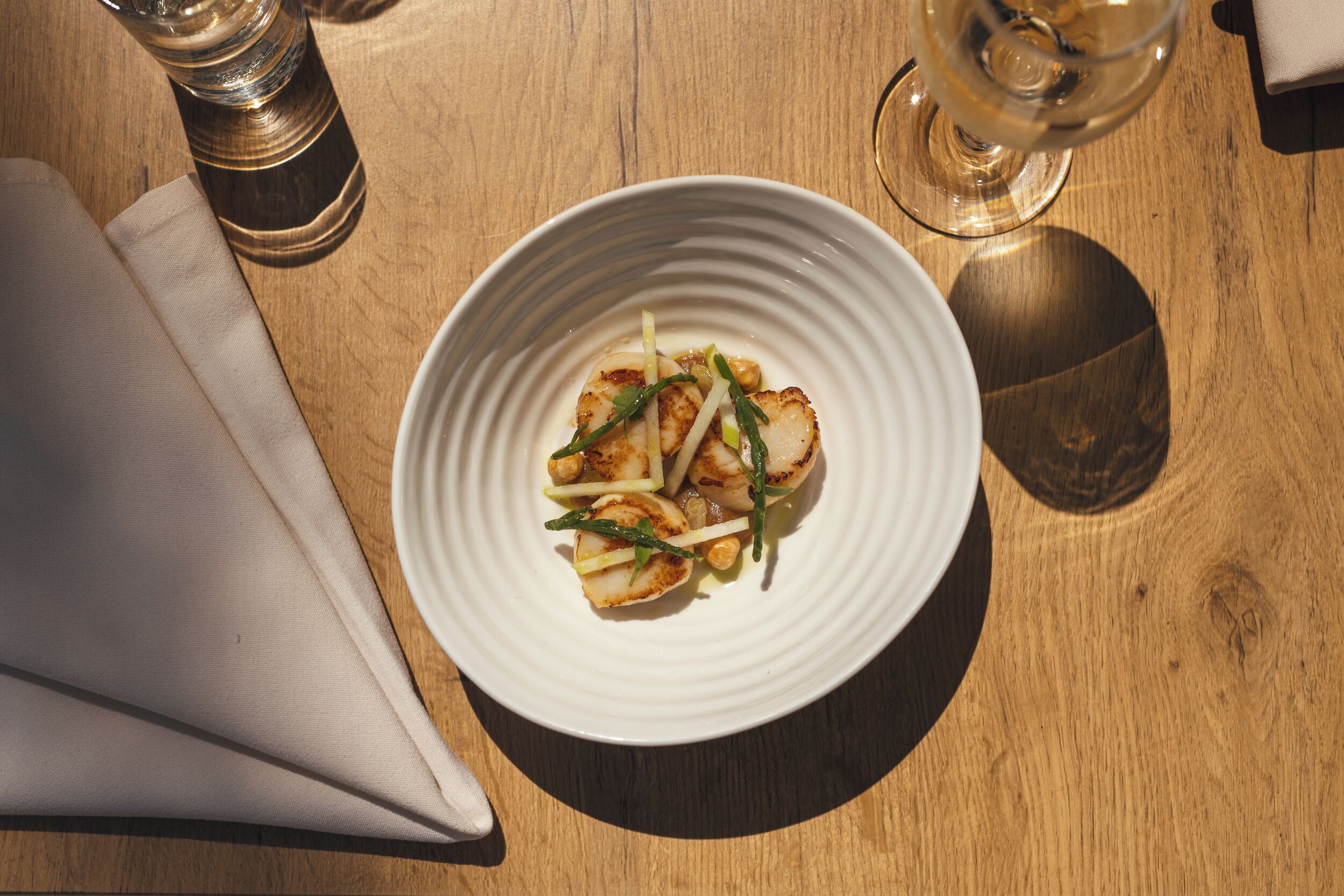 A white plate with food on a wooden table.