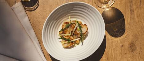 A white plate with food on a wooden table.