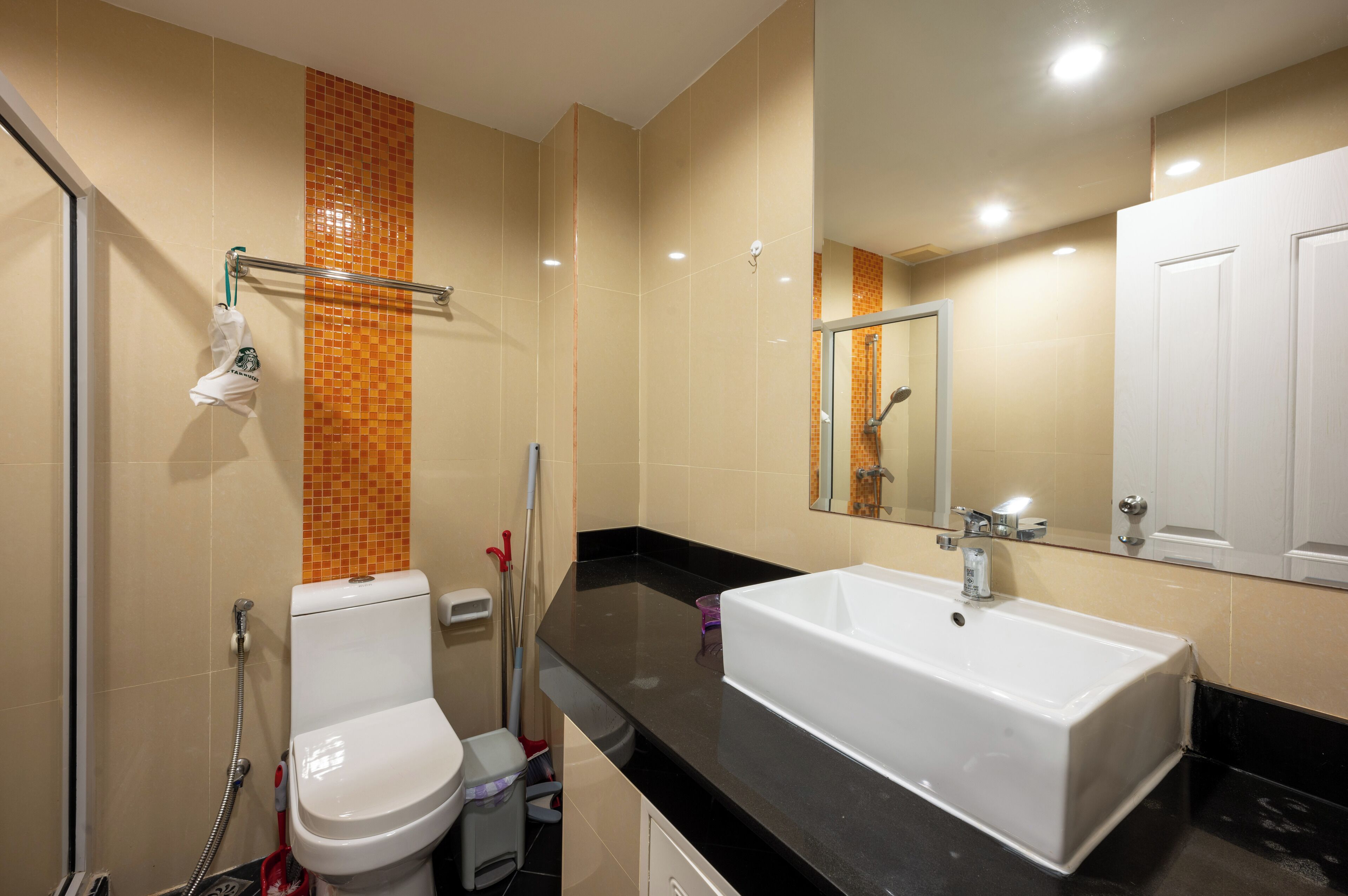Un baño moderno con un lavabo blanco, una cabina de ducha de vidrio y un espejo sobre el lavabo.