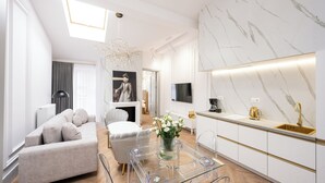 A modern living room with a sofa, ottoman, and a glass coffee table with a vase of flowers. - Native Apartments Starowiślna 43 (Kraków)