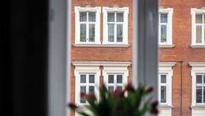 A view of a red brick building with white-framed windows and a white door. - Native Apartments Starowiślna 43 (Kraków)
