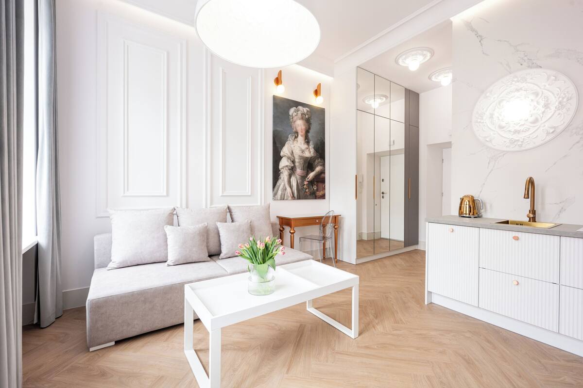 A modern living room with a sofa, coffee table, and a painting on the wall.