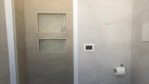 A small bathroom with a shower, toilet, and a towel rack. - Barone Beach Hotel (Rimini)
