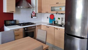 A modern kitchen with a gas stove, a built-in oven, a toaster, and a stainless steel refrigerator. - A Pochi Passi dal Chianti, Immersi nel Verde con Animali Ammessi (Cavriglia)