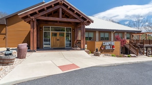 A building with a wooden facade, a sign reading "CAMPFIRE GRILL," and a wheelchair-accessible ramp.