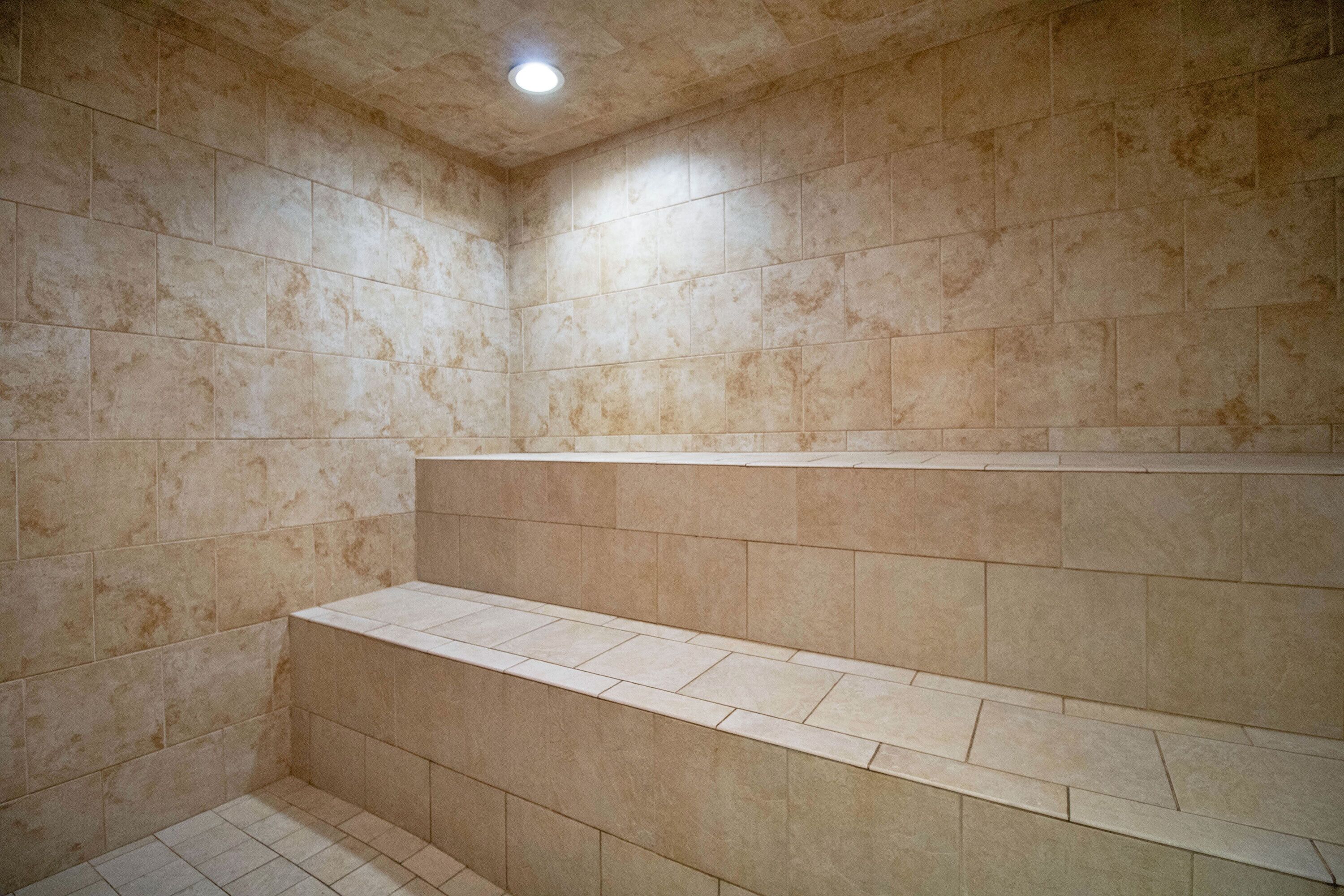 A tiled shower area with a built-in bench.