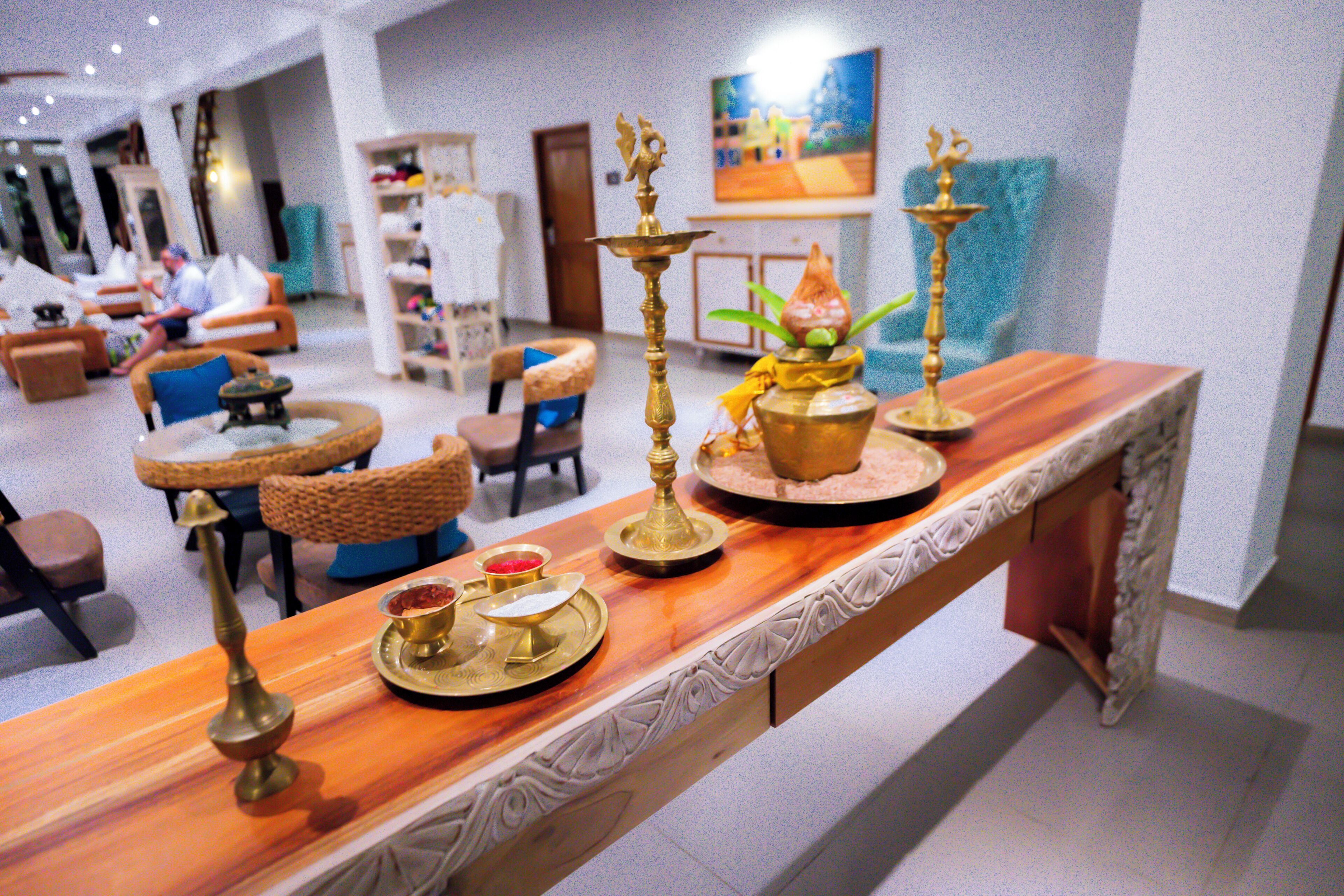 A reception area with a long wooden counter, a television, and seating arrangements including chairs and a sofa.