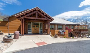 A rustic building with a wooden facade, large windows, and a sign that reads "CAMPFIRE GRILL".