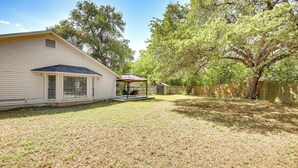 A single-story house with a covered patio and a fenced backyard. - Spacious San Antonio Home: Google Fiber, Game Room (San Antonio)