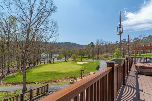 A golf course with a wooden deck overlooking the fairway.