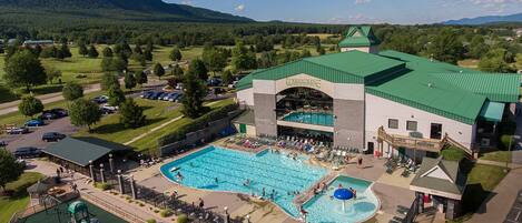 A hotel with a large pool, a water park, and a view of the surrounding landscape.