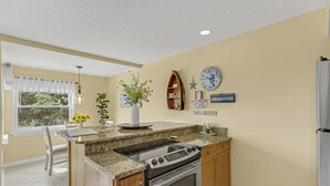 A kitchen with a granite countertop, stainless steel appliances, and wooden cabinets. - Haven Harbor Getaway (Melbourne)