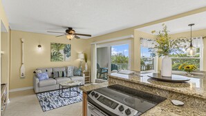 A kitchen with a stove, a dining area with a table and chairs, and a balcony with a view. - Haven Harbor Getaway (Melbourne)