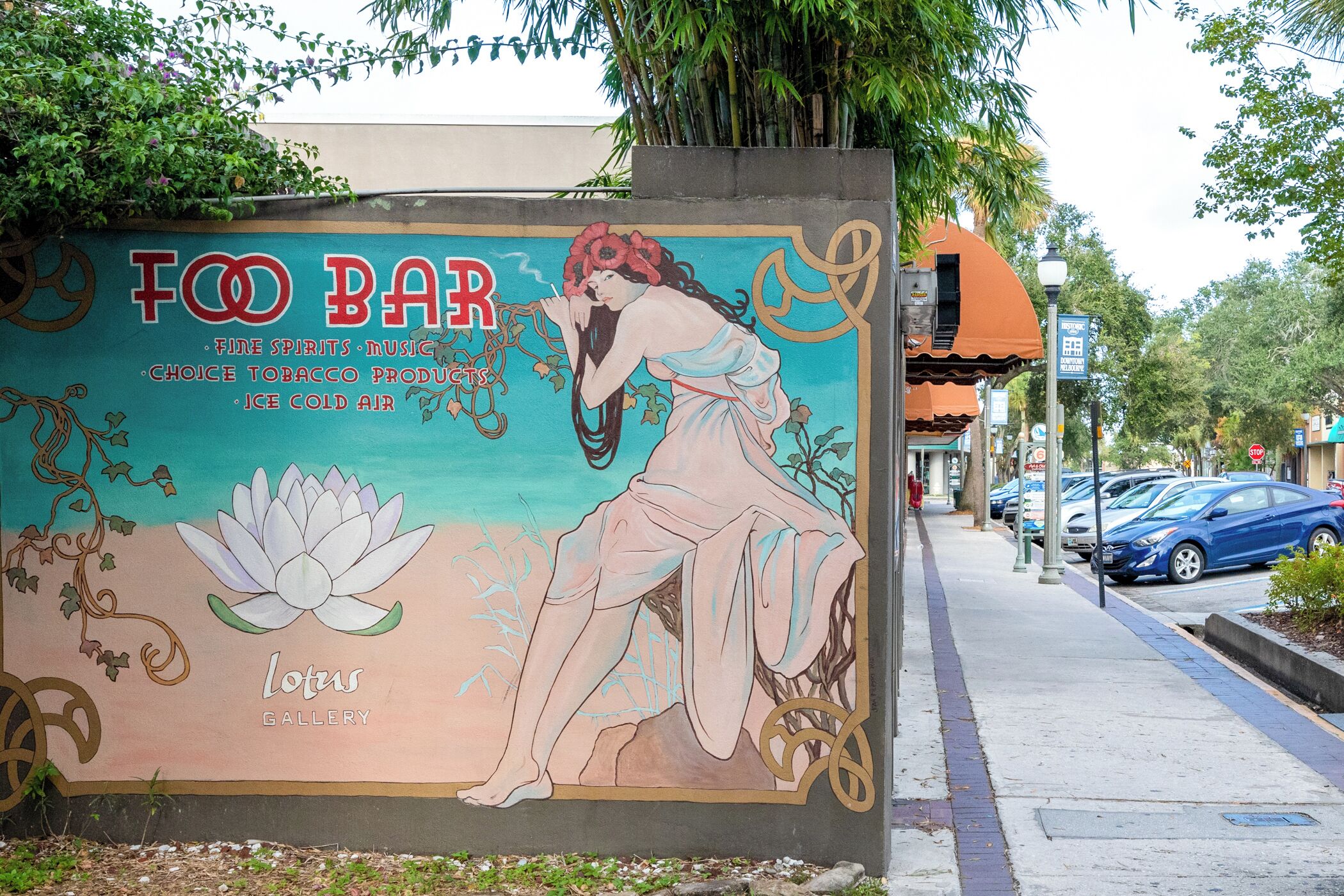 A mural advertising a Foo Bar with a lotus flower and a woman.